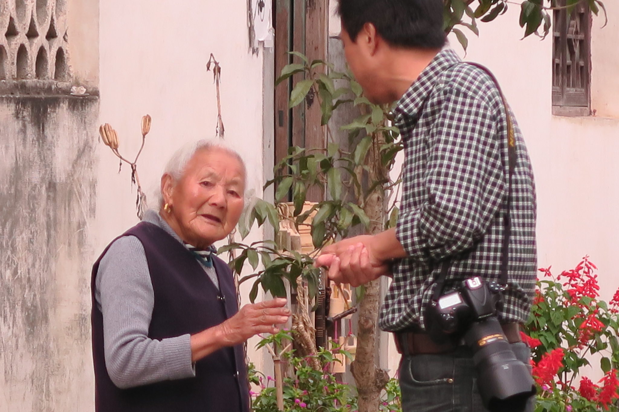 Una donna anziana sta litigando furiosamente con un fotografo che l’ha fotografata