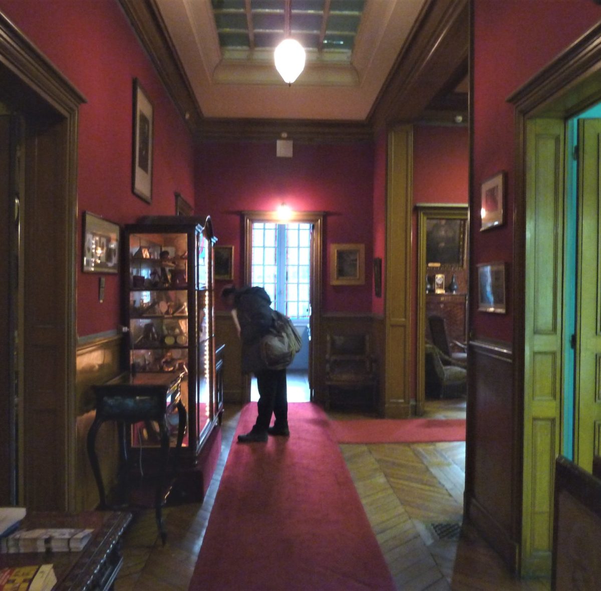 L’ingresso dell’appartamento di Pasteur . I velluti , le poltrone , i colori dei drappeggi , gli arredi danno la percezione di una casa che doveva apparire austera , piena di memorie , avvolta nel silenzio .